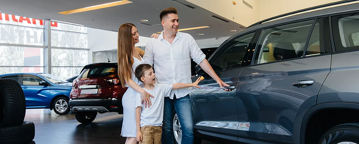 Family looking at a new vehicle in a car dealership