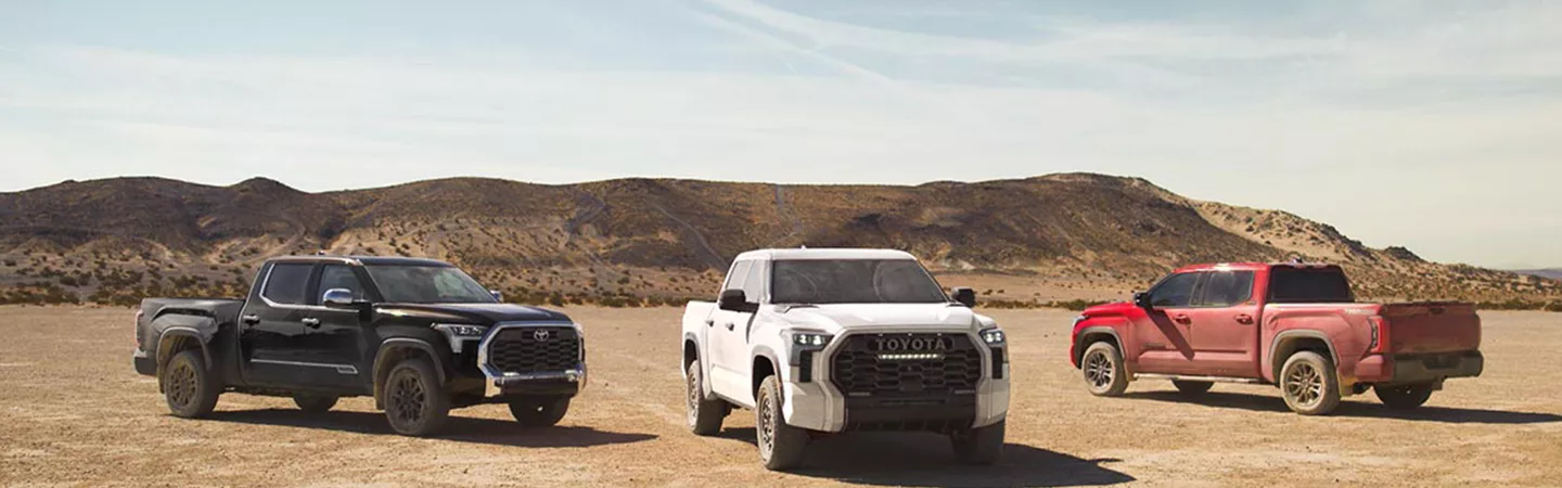 Three Toyota Tundra trucks parked in the desert