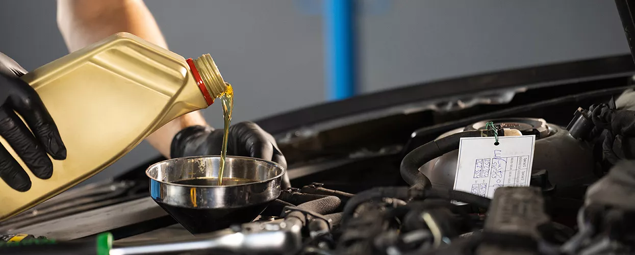 Service mechanic performing an oil change on a vehicle