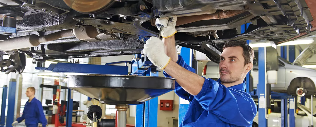 Service mechanic performing an oil change on a vehicle