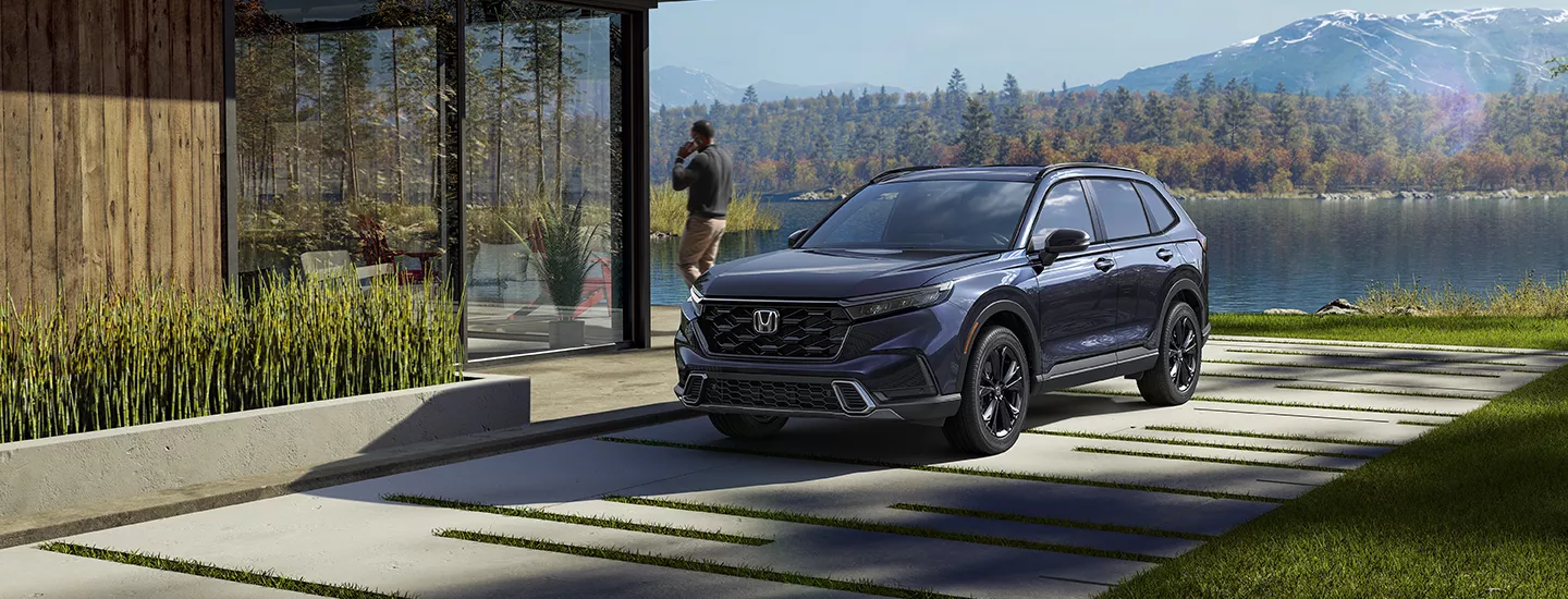 2026 Honda CR-V Hybrid parked in front of a home with mountains in the background