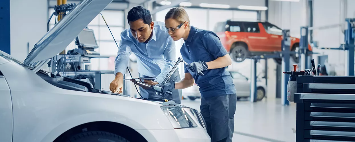 Car salesman showing a couple a new vehicle