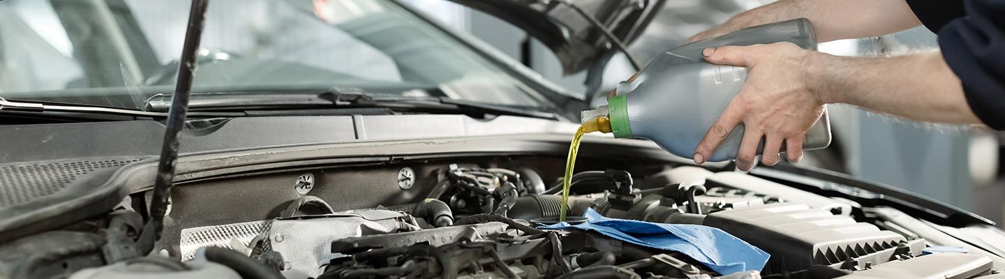 Service Technician Putting Oil in Vehicle