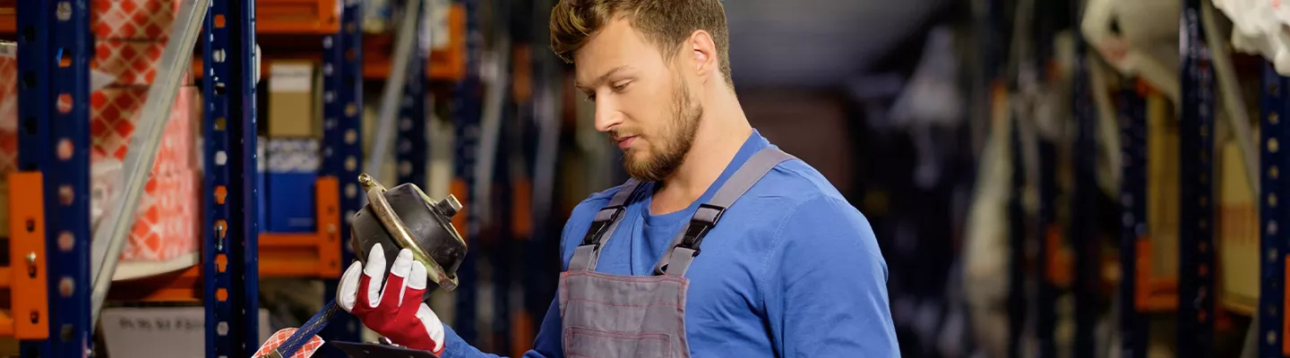 Service technician inspecting a part at Kia of Cape Coral