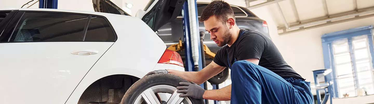 Service technician checking a tire at Kia of Cape Coral