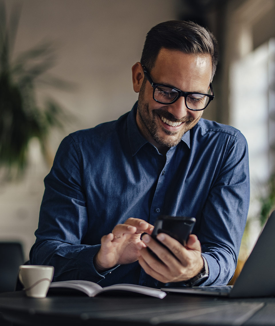 business man smiling on his phone messaging