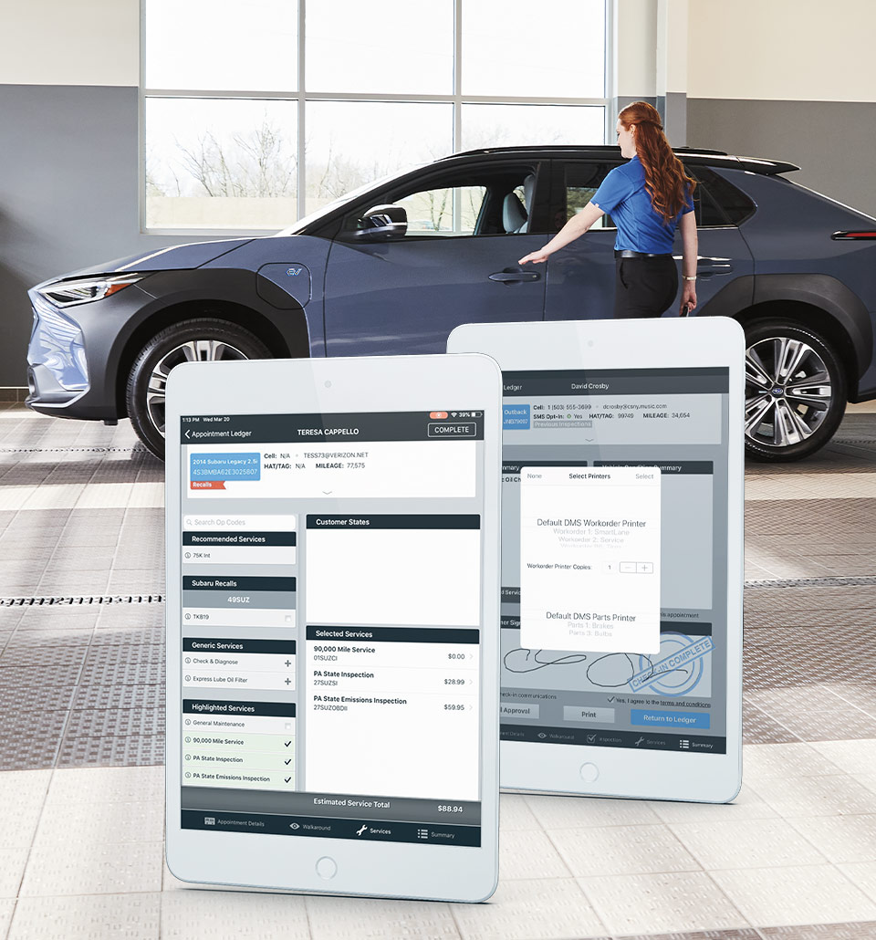 mechanic waving as Subaru driver reverses with view of rear of vehicle