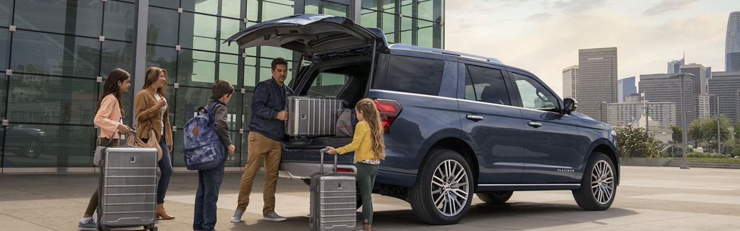 2023 Ford Expedition parked in a city and tailgate open with family unloading luggage
