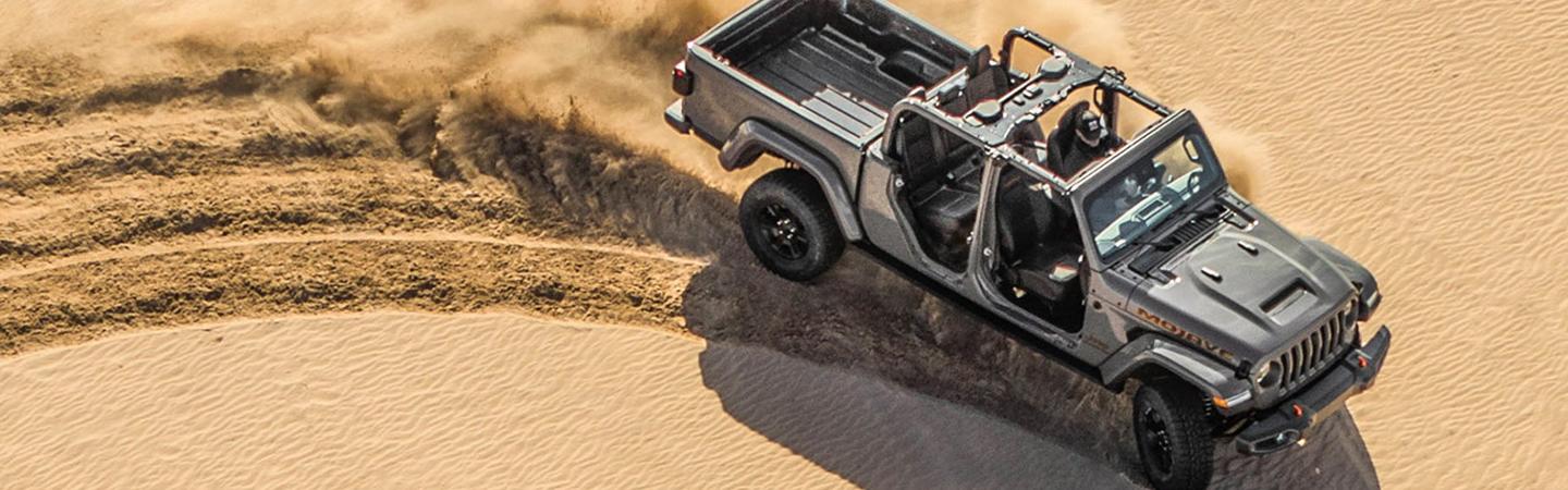 Overview of a 2021 Jeep Gladiator driving through sand