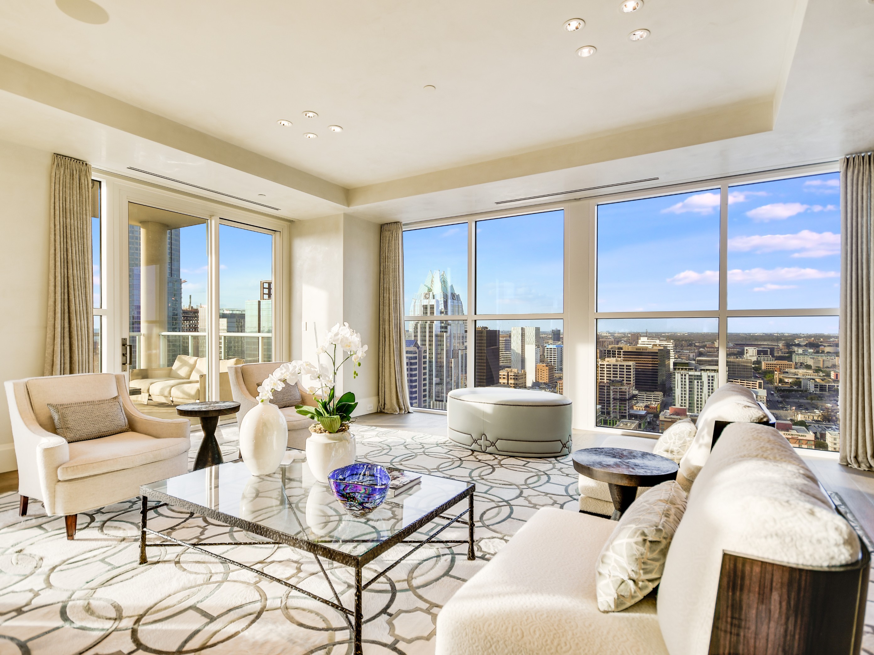 Encompassing a dramatic 13,000 square feet of masterful design, this astounding 30th floor penthouse delivers unparalleled luxury from the top of the Four Seasons and is only accessible by keyed elevators that open directly into the residence. Envisioned by FAB Architecture and created by the Escobedo Group, this residence takes contemporary style and elevates it to the highest echelon with interior design by the renowned Fern Santini. Heart-stopping 360-degree views show the entirety of Austin in its best light, with breathtaking scenes of Lady Bird Lake. QuietRock Panels installed in the walls, ceilings, and floors isolate the penthouse from the rest of the building, with a fully-automated Savant smart home system offering complete separation. One-of-a-kind finishings include sleek custom-stained white oak floors, a hand-crafted, fluted limestone fireplace in the formal living room, and a bathroom with an antique vanity mirror and a 500 lb Taj Mahal quartzite counter. Custom artwork embellishes the entryway from the elevators, which are equipped with security system controlled cameras. The main kitchen divides the formal areas of the home, family spaces, and guest suites, with floating Bulthaup cabinets and Miele appliances. The guest suite includes a full kitchen, dining room, living room, den, bedroom, large walk-in closet, and a full bathroom. Other unique features include a 500-bottle wine cellar with custom steel doors, balconies outfitted with dog-friendly charcoal filtered turf, a media room with a metal halide 4k projector, and a service/freight elevator that opens into a transitional area for pet entry. Truly a building-within-a building, this decadent residence is unequaled in caliber and location.