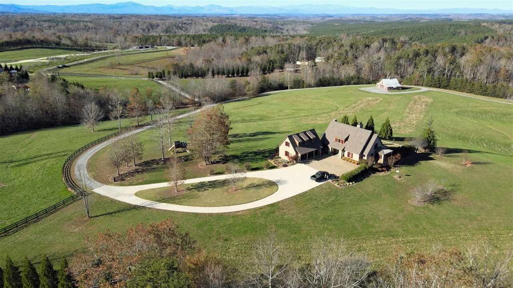 Listing courtesy of NC/SC Realty. Rock Creek Farm is a Spectacular Property located in Green Creek, NC, just a few miles East of Tryon , Landrum & TIEC. This amazing property boasts 2 custom built homes by Edney Construction, a large 2200 SQFT barn with a loft, concrete floor, & stables, and 73.5 Rolling Acres!! From the Main home you will enjoy 180 degree panoramic mountain views & stunning sunsets all year long!! Both Homes feature exquisite craftsmanship & attention to detail every where you look boasting: Handmade Hickory Cabinets & Built-In Shelving, Queens Arch Vaulted Ceilings, Italian Marble Countertops, Australian Cypress Flooring, Damascus Quartz, and even special order tiles from the Bronx in New York City! The main home has 5125 SQFT and features locally milled heart of pine flooring throughout, a 3 car garage with a 2nd floor, 4 Bedrooms (en-suites) each with their own full bathroom, 2 additional half baths, multiple fireplaces, an inground swimming pool, a hot tub, a temperature controlled wine cellar & a full wet bar! In the kitchen you will find amazing tile work, Viking, & Sub Zero Appliances, one of which is a 6 burner gas stove! In the dining room you will find a trey ceiling made of cedar! The main floor living areas lead out to great outdoor space - a screened porch with a fireplace and a large deck that spans the back of the home, which are perfect for entertaining!! Deer Run Cottage is the other custom built home on the property and has 1800 SQFT, 3 bedrooms & 2 full bathrooms. It features Thermador Appliances in the kitchen along with leathered Carrera Marble Countertops! The living room has a vaulted ceiling and a fireplace with slate surround. 2 Full Bedrooms and Bathrooms on the mail floor, while the upstairs features a large loft bedroom with 3 closets, & a full bath with a claw foot tub.