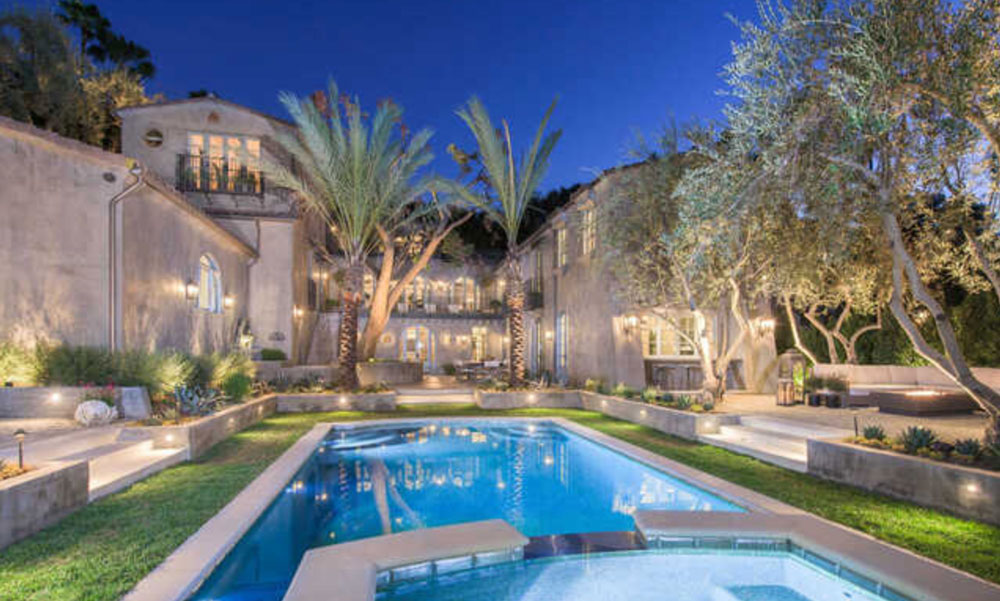 Behind the gates of exclusive Laughlin Park, this recently-reimagined Spanish home, showcasing elegantly bespoke design by Xorin Balbes of TempleHome, blends the best of the Old and the New World. Entry courtyard with firepit leads to privately gated 5-bdrm estate. Grand living room with massive fireplace and the home's original wood beam ceiling raised to soaring heights sets the dramatic tone. On one wing is the chef's kitchen, grand formal dining room, spacious family room and a more intimate dining room. On the other, an office and a luxurious master suite. Upstairs is 2nd sumptuous master suite and 2 luxe guest suites. Add'l amenities incl an abundance of natural light, theater, gym, sauna, additional 5th bdrm suite, pool house, wine wall, 3-car garage, the latest technology in sound/lighting/automation, views of the Observatory, and a generous indoor lounge with fireplace leading to outdoor dining, a spectacular pool, sunning and lounging areas, and romantic and mature gardens.