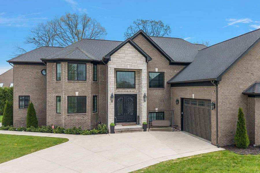 Welcome to an exquisite custom-built all-brick estate, set on nearly half an acre of beautifully landscaped grounds. Constructed in 2017, this luxurious 4-bedroom, 4-bathroom residence features a grand bonus room above the garage, perfect for a fifth bedroom, elegant office, or sophisticated media room. The main level is an entertainer's dream, boasting an open-concept design with soaring ceilings, rich hardwood and tile flooring, and a gourmet kitchen adorned with quartz countertops, shaker cabinets, and an expansive walk-in pantry. The inviting family room, with its elegant fireplace and abundant natural light, offers a refined space for gatherings. A private den or office provides a secluded workspace. Indulge in the opulence of two primary suites, each with spa inspired bathrooms and walk-in closets, one on the main floor with patio access, perfect for multi-generational living. Dual laundry rooms enhance convenience for busy households. Upstairs, discover two additional bedrooms connected by a Jack and Jill bathroom, and an oversized bonus room offering versatile living options. The finished basement, with generous storage and provisions for a second kitchen, adds further luxury. This home is adorned with premium details, from Andersen fiberglass windows and stylish lighting to plush carpeting and superior brickwork. Constructed with robust 2x6 framing, it combines durability with elegance. The expansive patio, surrounded by mature privacy trees, provides a serene outdoor retreat. Move-in ready, this residence epitomizes luxury living, designed with comfort and enduring quality in mind.