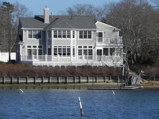 All aboard! Deep water dock takes you from this waterfront home to your boat. Large windows pull the water right into this spacious 3 bedroom home. Cathedral ceilings and an open plan give you space for relaxing. The sun seems to set over the water at the end of a long day from your private wraparound waterside deck. This custom contemporary glimmers with hardwood floors, custom lighting, wet bar, granite kitchen countertops and many other extras. Enjoy the sparkling water views and fantastic deep water dock leaving you only a short boat trip to Martha's Vineyard..