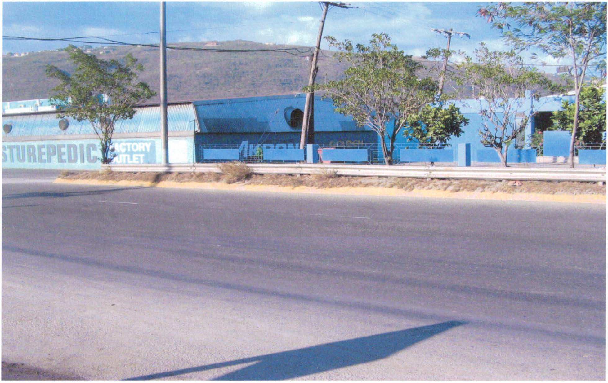 This commercial and industrial property known as Beep Beep Tyres Batteries and Lubes Limited is situated at 585 Spanish Town Road in the parish of St. Andrew. 
Bounded on the north by Callaloo Mews, on the south by Spanish Town Road, on the east by K.I. Agenci)s, on the west by McIntosh Bedding. 
As shown by Title Plan the land is approximately3 roods 38 perches (43050.4 square feet) (3999 square metres) with a frontage on Spanish Town Road of 143.20 feet (43 metres) and depth of 324.88 feet (98 metres) more or less. The holding with well drained lands, boundaries of concrete blockwalls, chainlinkwire in concrete blockwalls supported by galvanised posts, ample asphalted driving and parking area is situated in a well developed commercial and industrial area with heavy vehicular and pedestrian traffic and is surrounded by various other well established commercial enterprises.