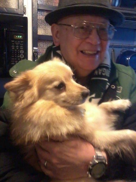 Dave Rafferty holding Tibbs, a dog owned by
Tim Smalley and Betsy Rafferty at Christmas brunch at their house in Lansing.