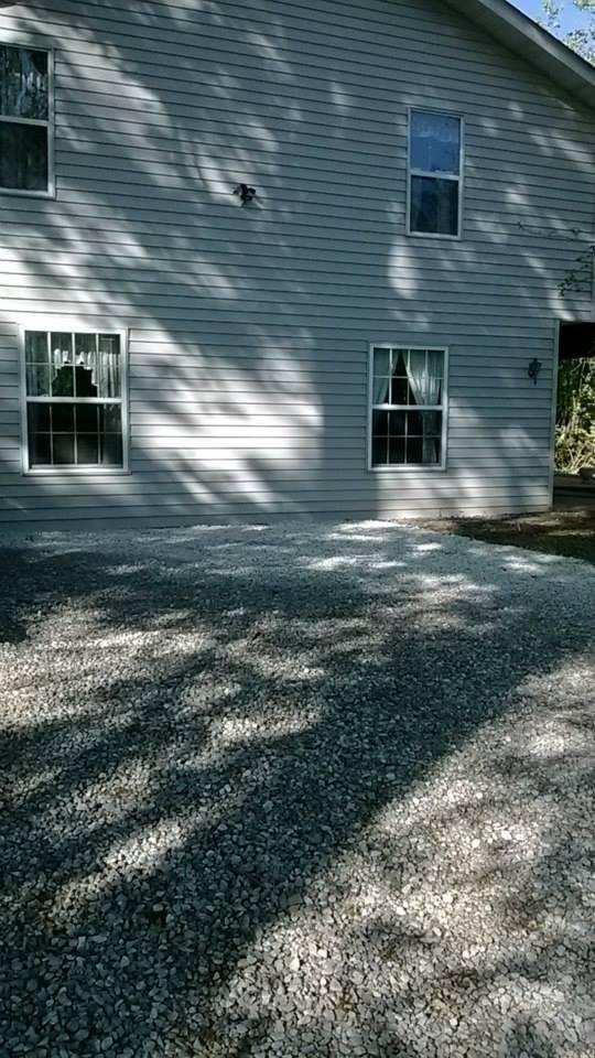 showing 1 side of house by side retaining wall and back drive