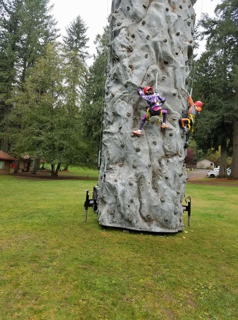 Elizabeth climbing rock wall and she made it to the top yea