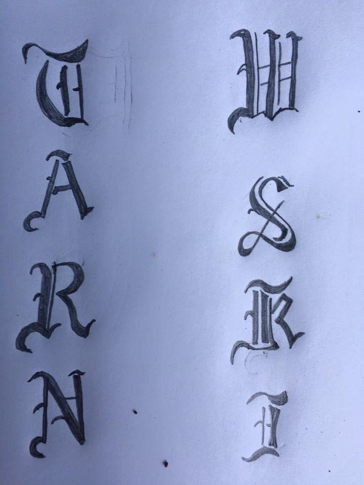 Crest for behind the sword carved in to wood lettering as shown