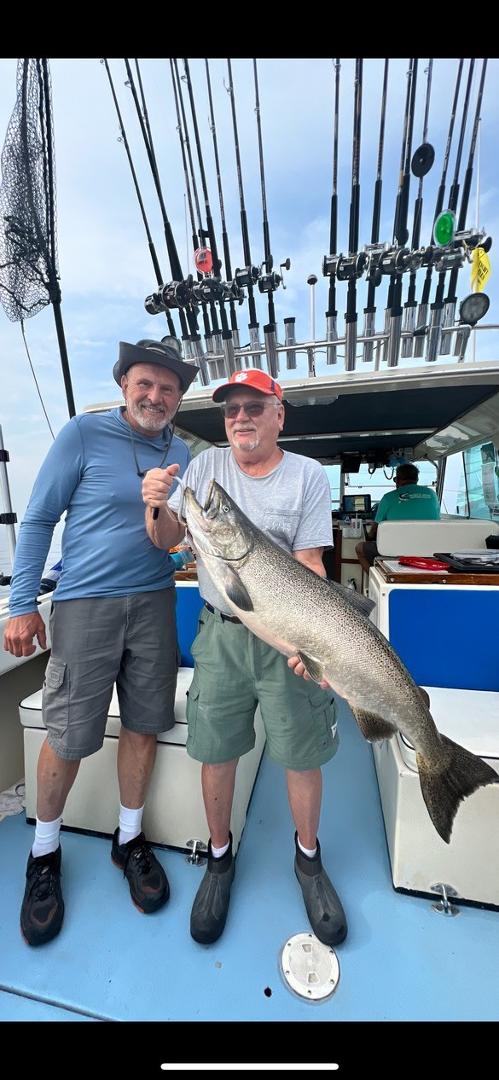 This me standing with my brother-in-law, AJ and his fish, the largest salmon caught that day last July on Lake Michigan. We are on EMU teammate Eric Walline's, Gulf Coast Charter Boat out of Frankfort, Michigan. Eric is in 