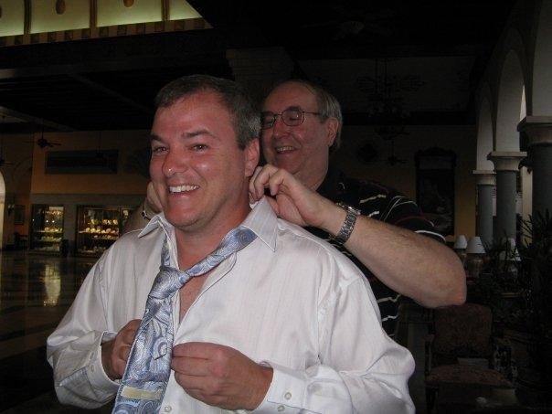 Step-father-in-law teaching groom to tie a tie