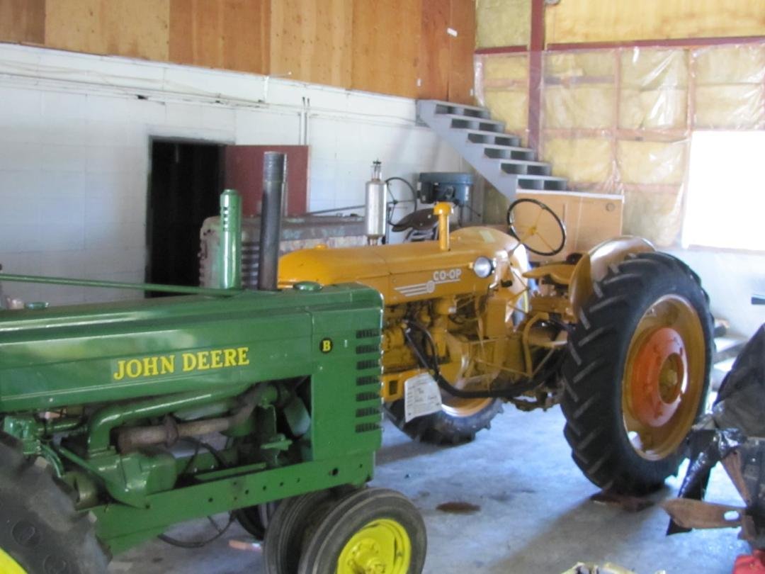 This is a picture of the left side of the COOP Model E-3. This picture shows that the Model E-3 has been fitted with two pair of rear wheel weights. The outer wheel weight has been a more orange color than our tractor. T