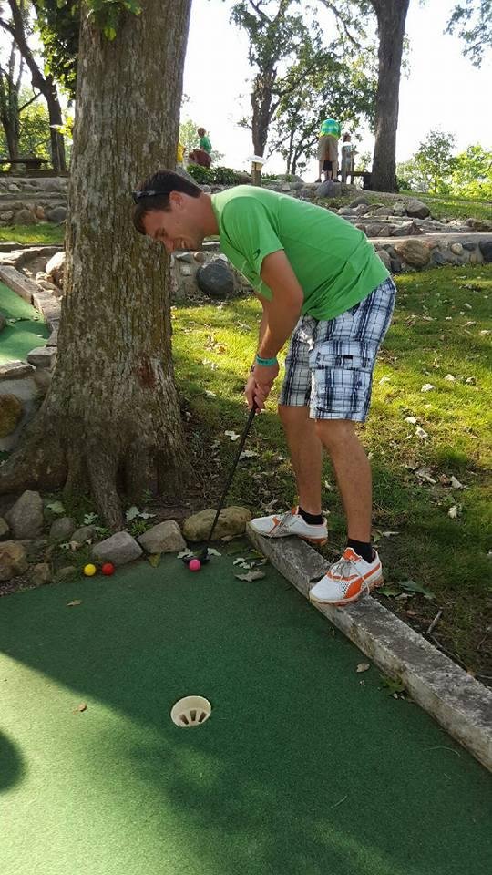 Drew at Family Camp playing miniature golf best shot.