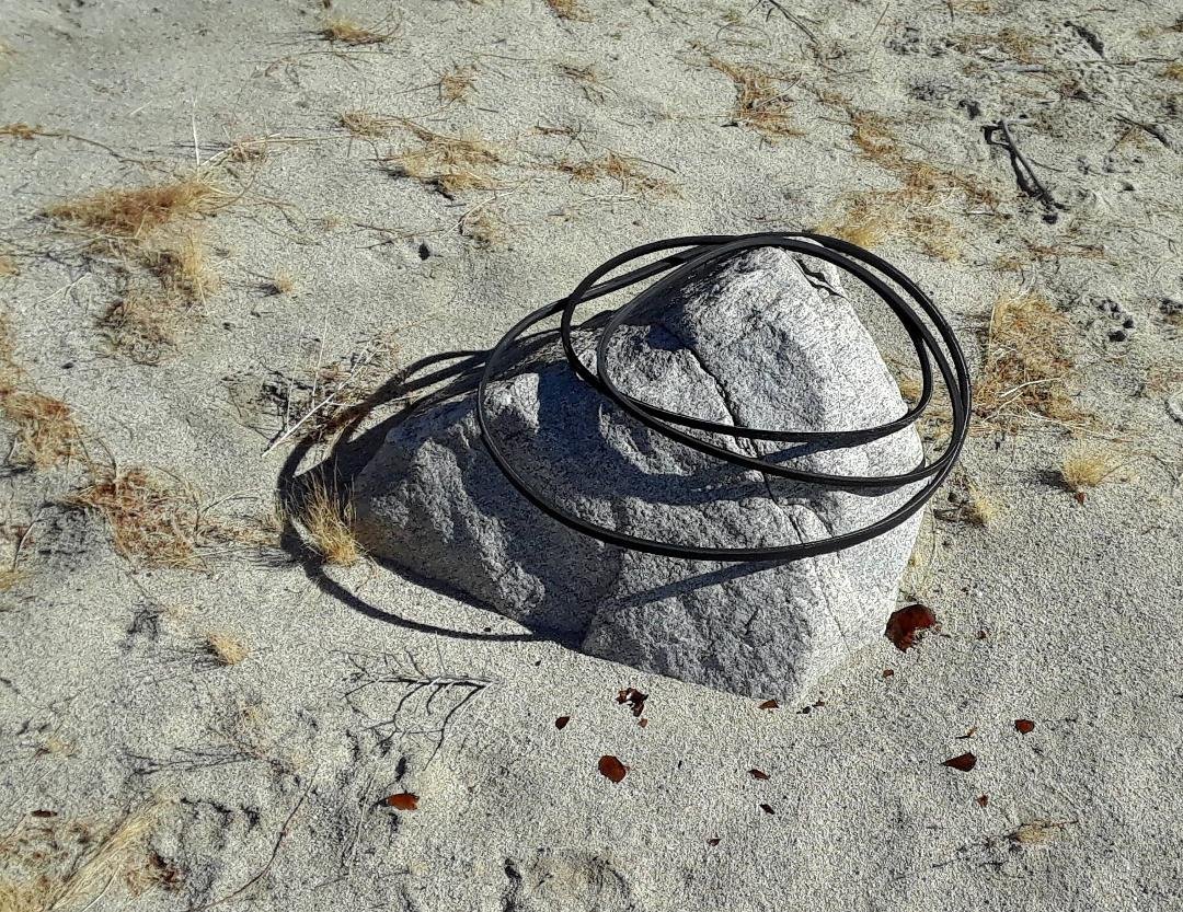 You can find the strangest things in the desert.
This rock is decorated with 3 automotive fan belts and their shadows. 1/4 mile off the nearest road on a foot trail.