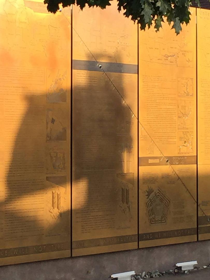 The hole in the girder causes the sun to shine on the medialions at the exact times the planes hit