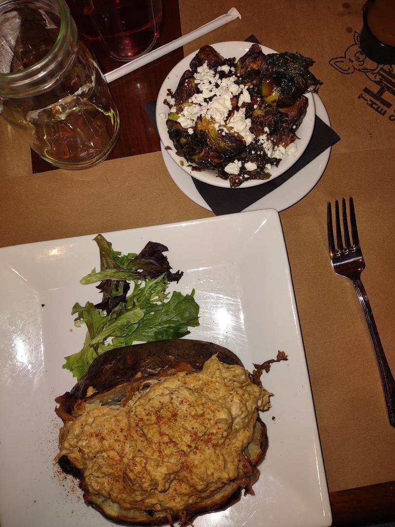 Crabby potato... baked potato topped with pulled pork BBQ and Crab dip, and the most incredible Brussels sprouts, blackened w/pecans, bacon, and goat cheese 😋😋😋