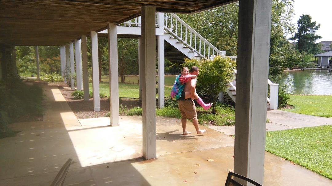 Matt playing horsey with injured daughter at the lake