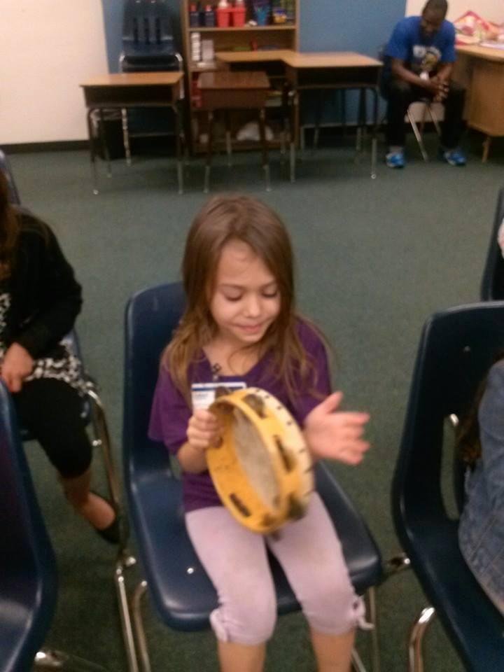 Julianna playing tambourine in mudic