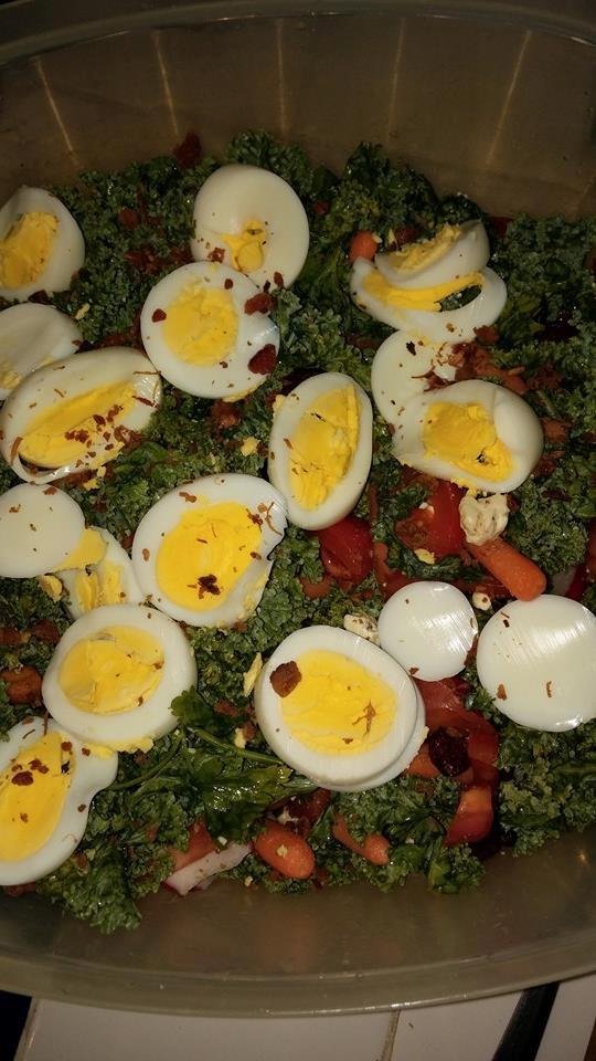 This is my creation massage kale with tomato,eggs,radishes,carrots,dried papaya, pomegranate raisins,trail mix,bacon bits.covered with raspberry walnut vinaigrette.