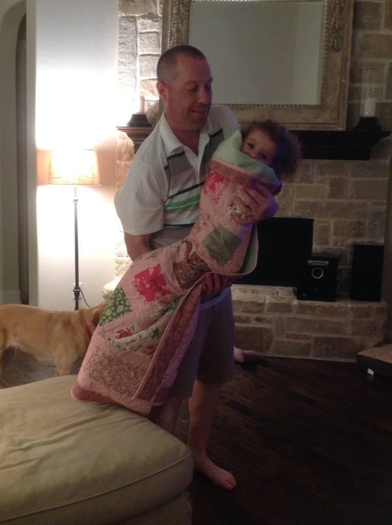 My nephew, Justin, holding my great-niece, Sophia, wrapped like a burrito in the quilt my friend Gina Ordonez and I made. Nancy and I are visiting down in Frisco TX.