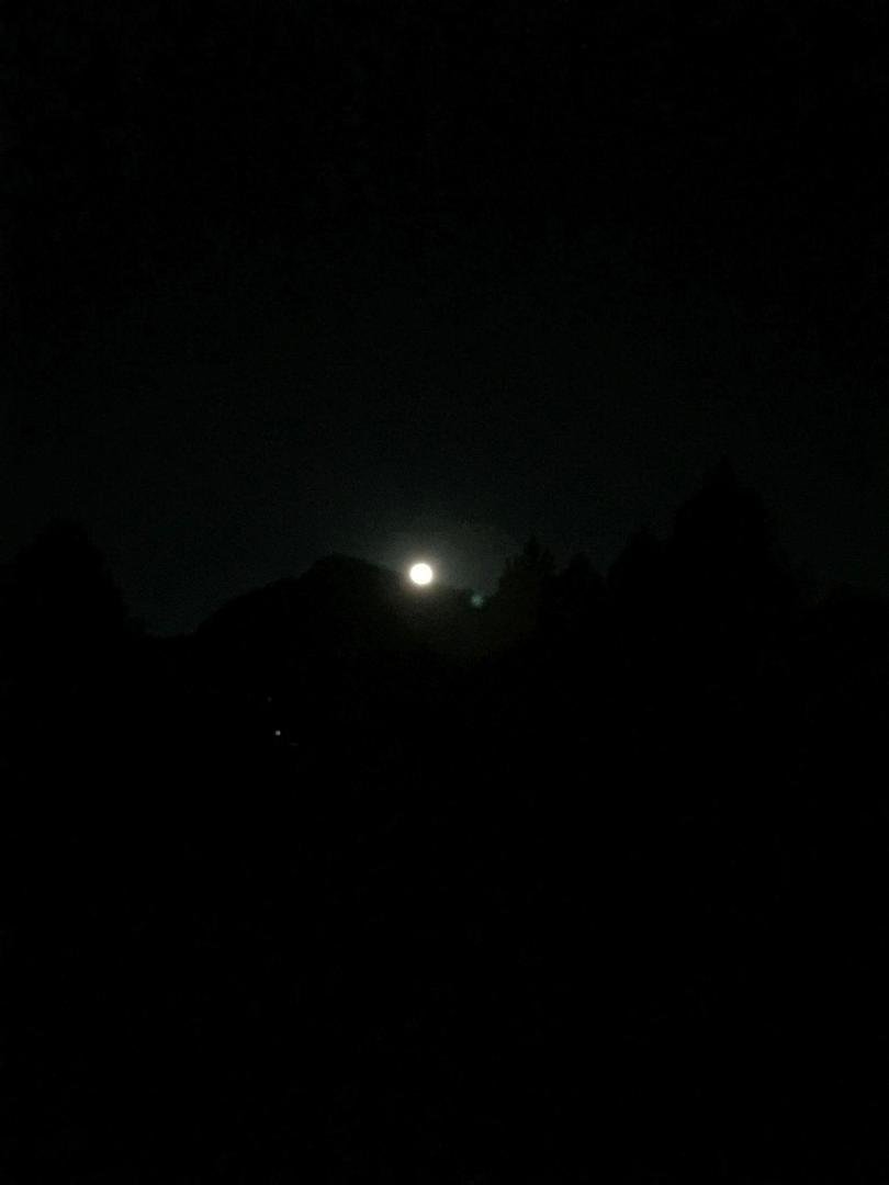“The Special Giant Moon” over a dirt parking lot or a button over the same parking lot.