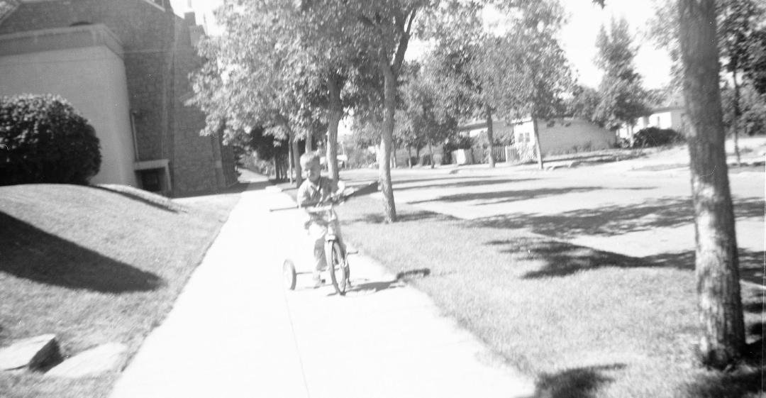 Missing the innocent good old days - no one thought anything of a boy on his tricycle playing cops and robbers...I was probably "the robber" hiding in the bushes.