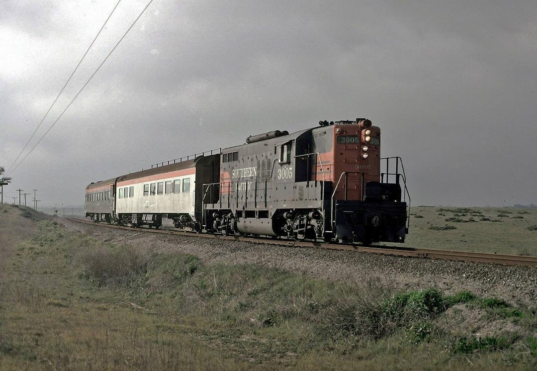 SP GP9 #3005, one of the roads four "Torpedo  Boat" locomotives, is approaching Castroville with  a two-car train heading for The City. It   is March  of 1971.