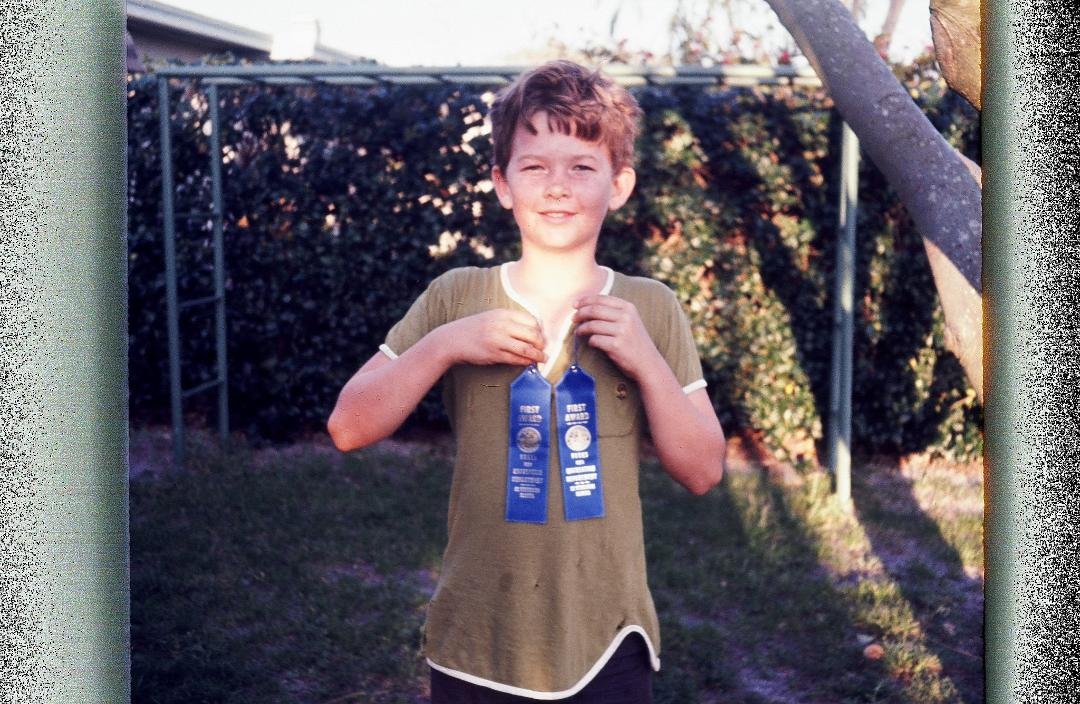 I'm glad my Dad took so many picures. One ribbon was for the standing broad jump, the other for the running broad jump. He built the monkey bars in the backgound.