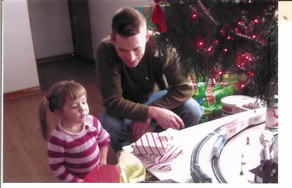 Uncle John and his niece Avery watching the train go 'round under the Christmas tree on Christmas Day.