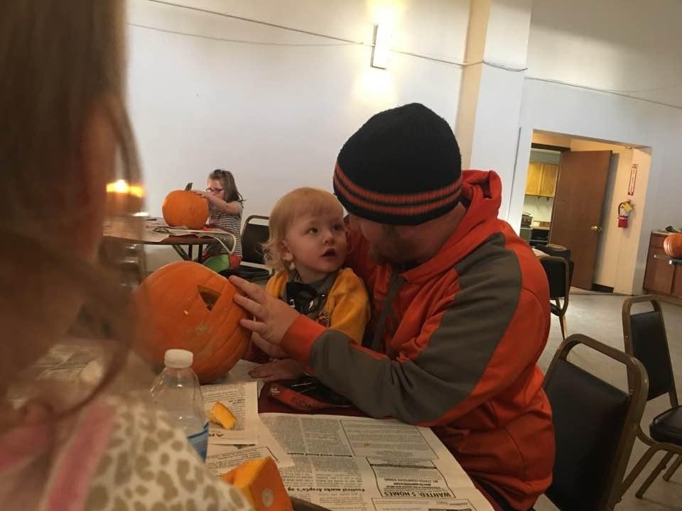 Uncle Dillian helping Kyle carve his pumpkin