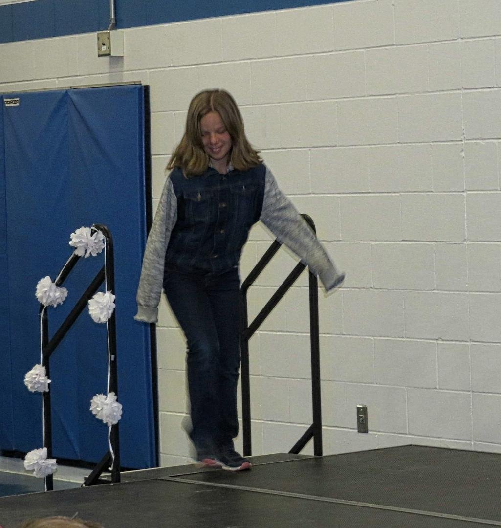 Isara walking onto the stage to receive her certificate of successful completion of her elementary school education.