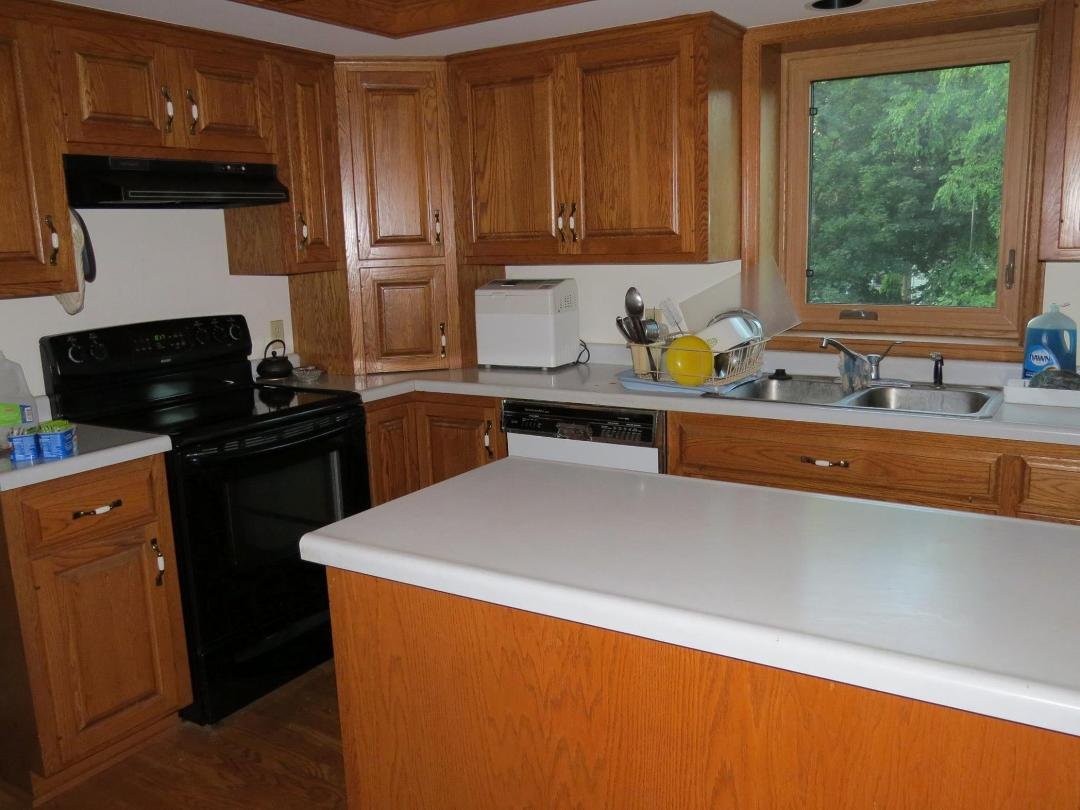 This is what our kitchen looked like before the current upgrades-- laminate countertops, stainless steel sink, chrome faucet, old dishwasher, appliance garage in the corner near the stove. We had the appliance garage remove