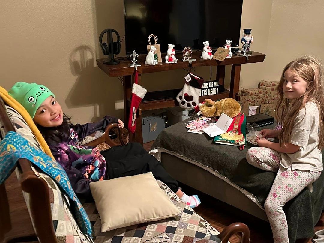 Sophie and Rebekah going through their stockings on Christmas Eve.