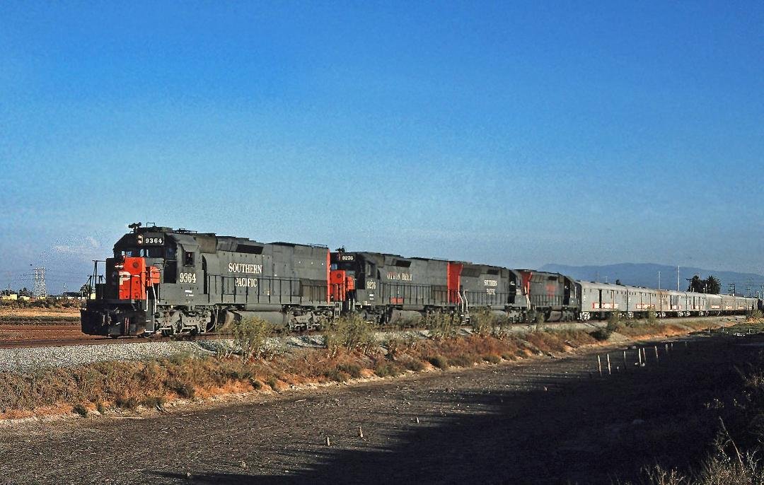 Alviso, CA, August of 1986, SP SD45-T2'S #9364 & #9276 and two unidentified SD45'S lead the Ringling Bros./Barnum & Bailey Circus train on it's way to the Oakland Coliseum.     The ice palace in San Jose had not yet been bu