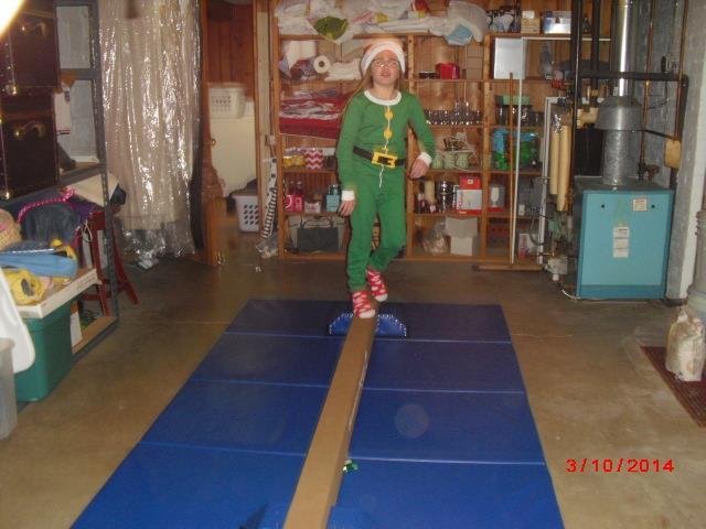 Riley followed a ribbon to the basement and found a beam and gymnastic mat from Santa!