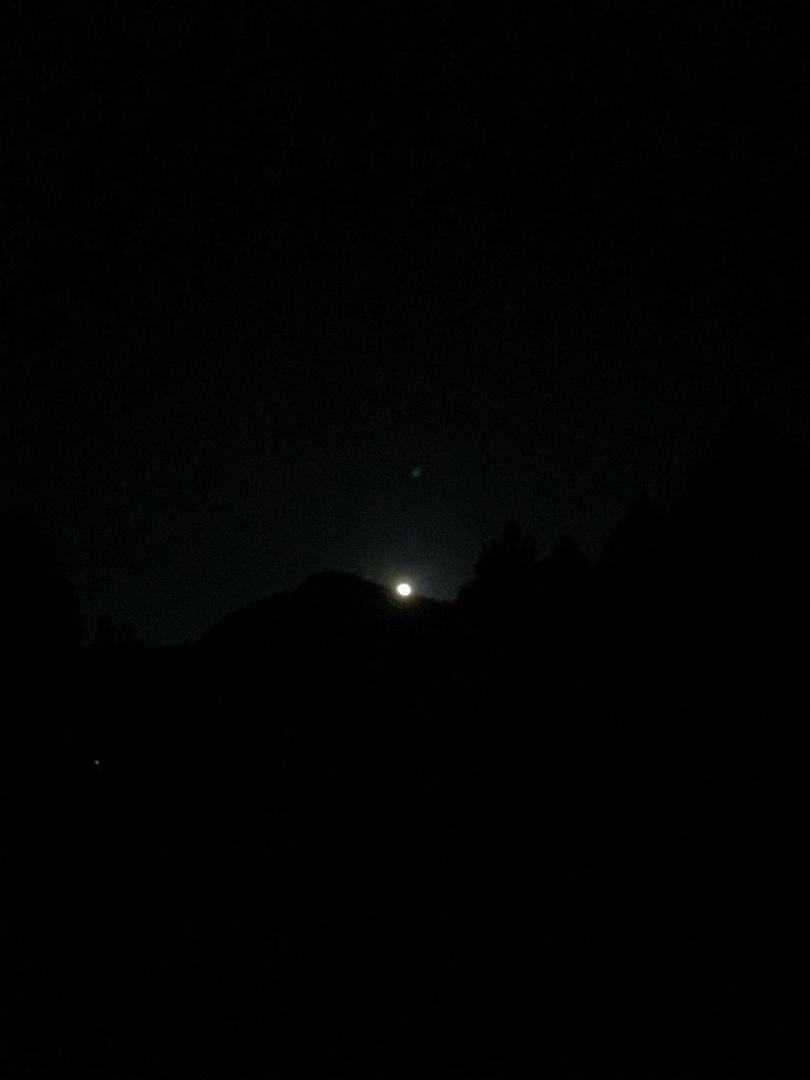 “The Special Giant Moon” over a dirt parking lot or a button over the same parking lot.
