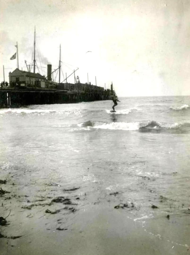 George Freeth is surfing next to Redondo Beach Pier. In 1907 Henry Huntington brought him from Hawaii to demonstrate surfing as a promotion of the recently opened Redondo Beach Plunge. Freeth lived for several years in Redo