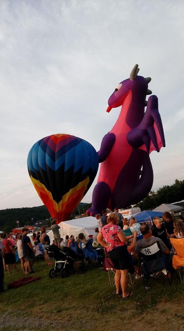 The 42nd annual Wellsville balloon rally is off and...floating! This photo shows a regular balloon next to this year's feature balloon, Scorch the Dragon...