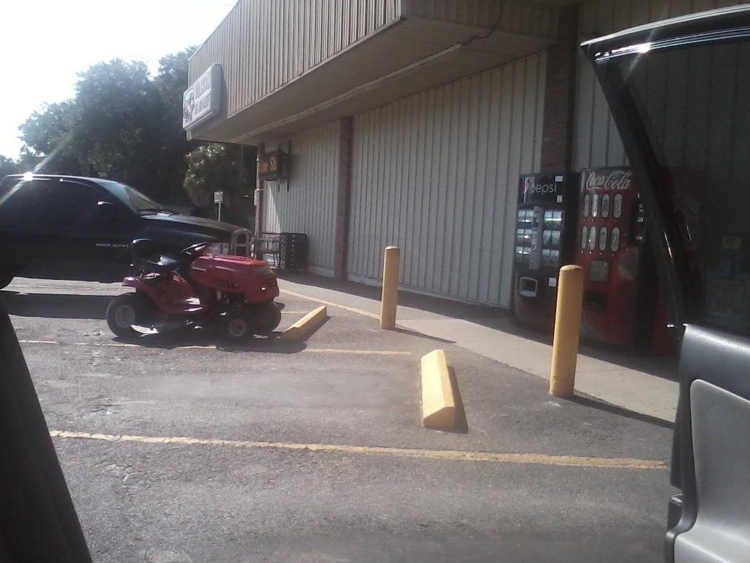 only in a small southern town would you see a lawnmower in the parking lot of the local grocery store.