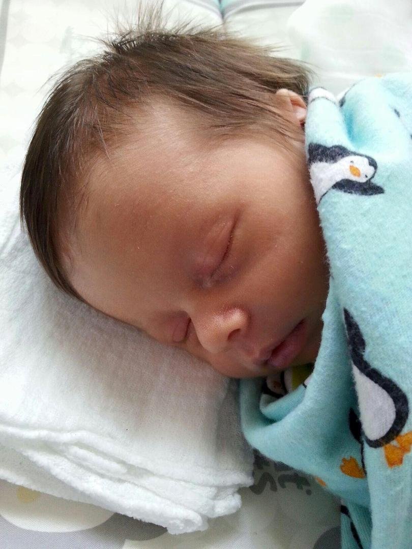 It's that cute grandson of mine again. One week old. His mom had to part his hair. He has so much!